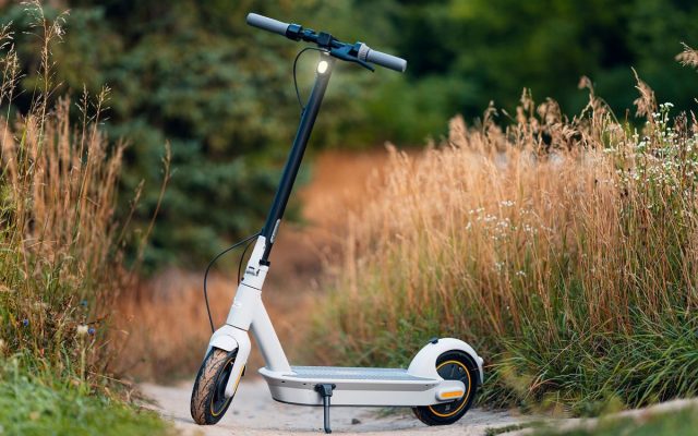 Eco-friendly electric scooter on a scenic rural path between tall grass and greenery