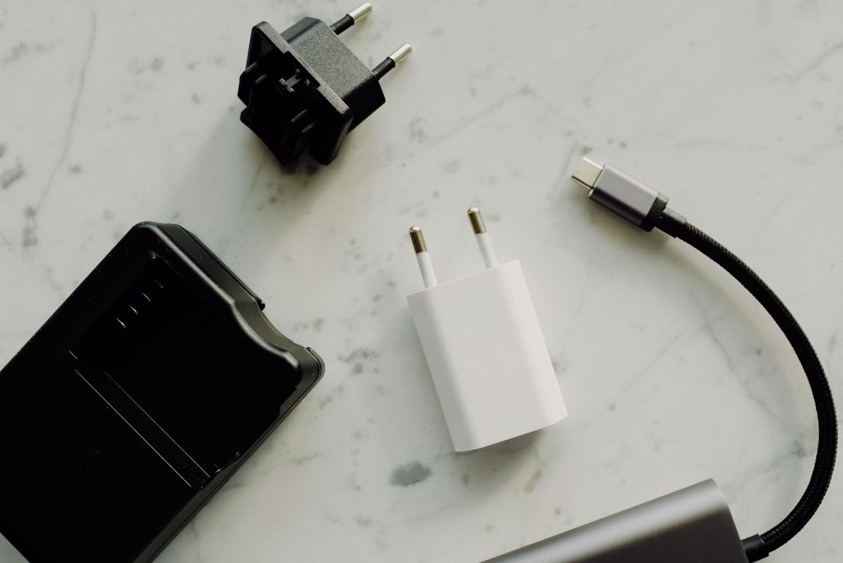 Flat lay of electronic adapters and chargers on a marble background