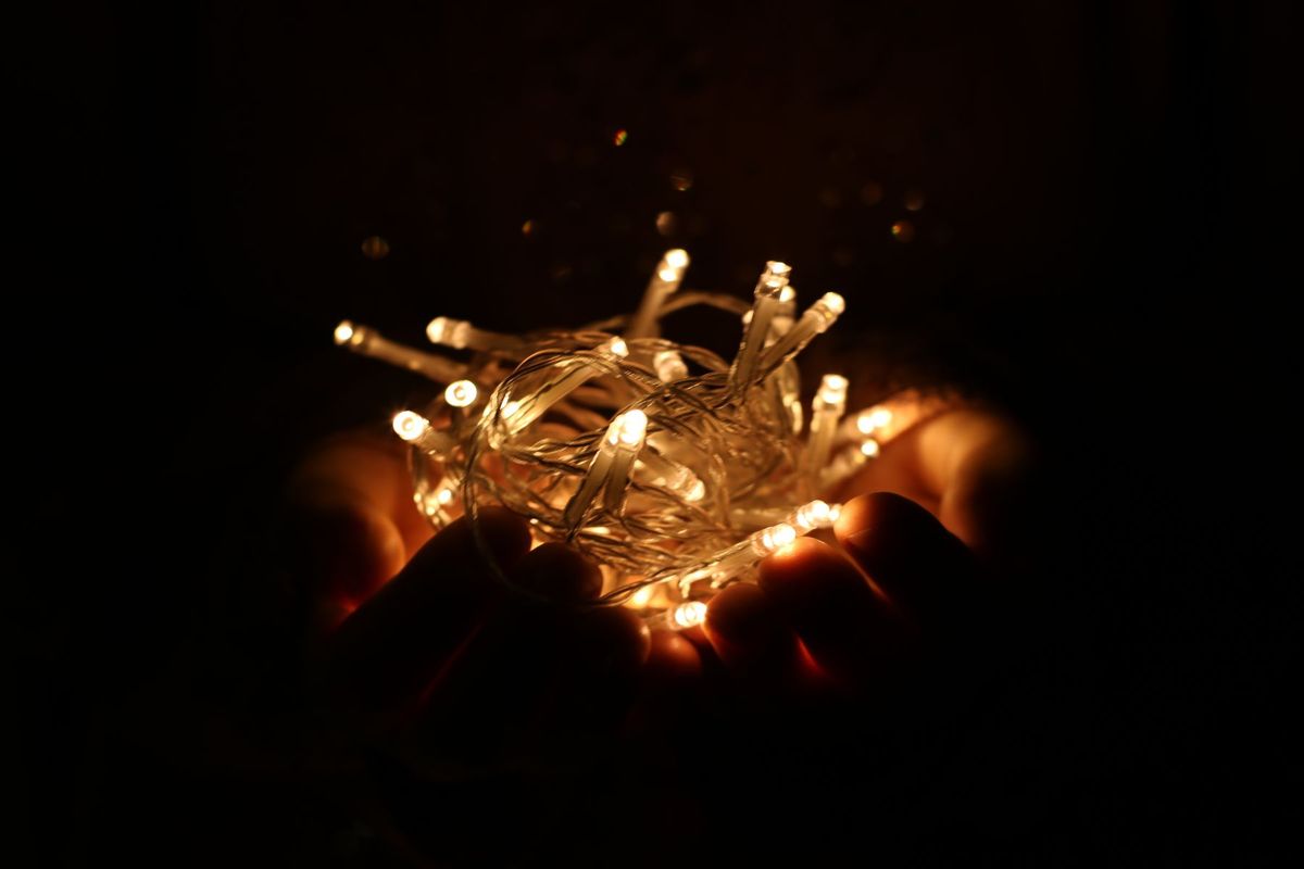 Hands holding glowing LED string lights