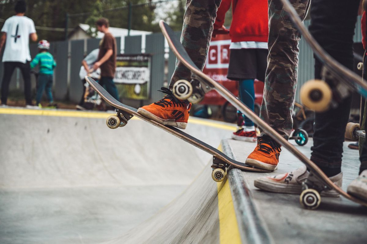 Kids and teens skateboarding at a lively outdoor skatepark