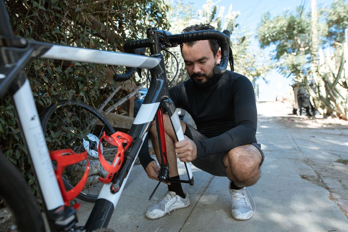 Man fixing a road bike on a sunny day