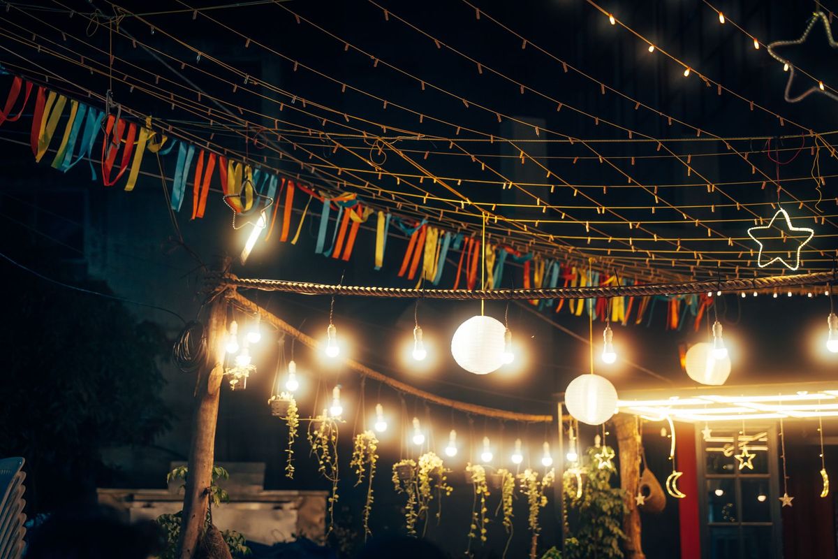 Outdoor string lights and decorations create a festive nighttime ambiance