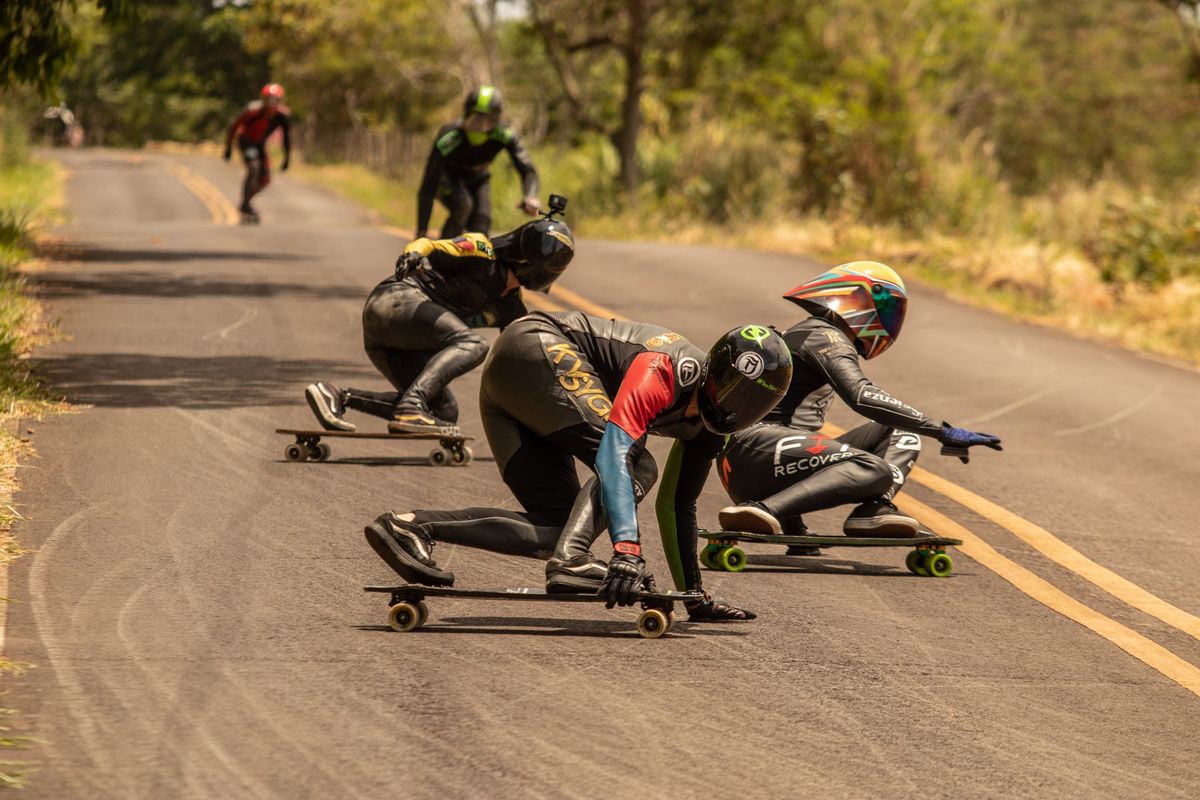 Skaters in action during a thrilling downhill longboard race on a winding road