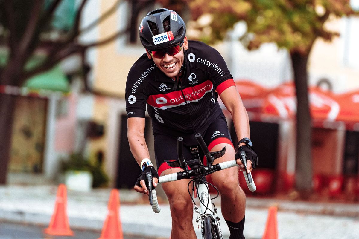 Smiling cyclist in helmet racing on road bike during a sunny day