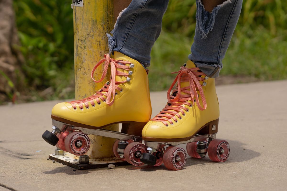 Stylish yellow roller skates with pink laces on a city sidewalk. Trendy and urban vibe
