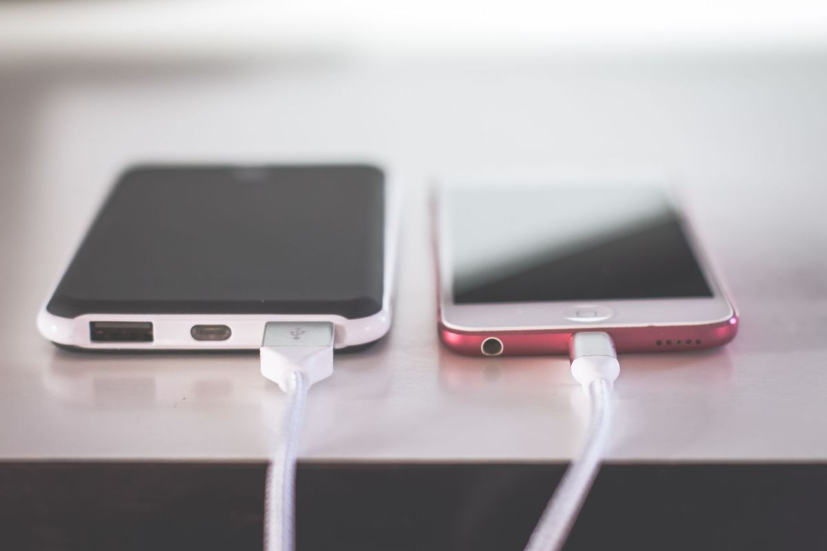 Two smartphones charging side by side on a desk. Modern and technological setting