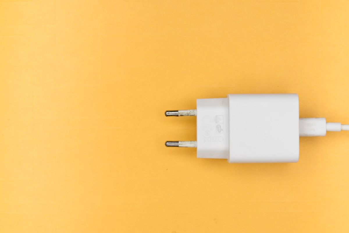 White charger plug on a clean yellow background