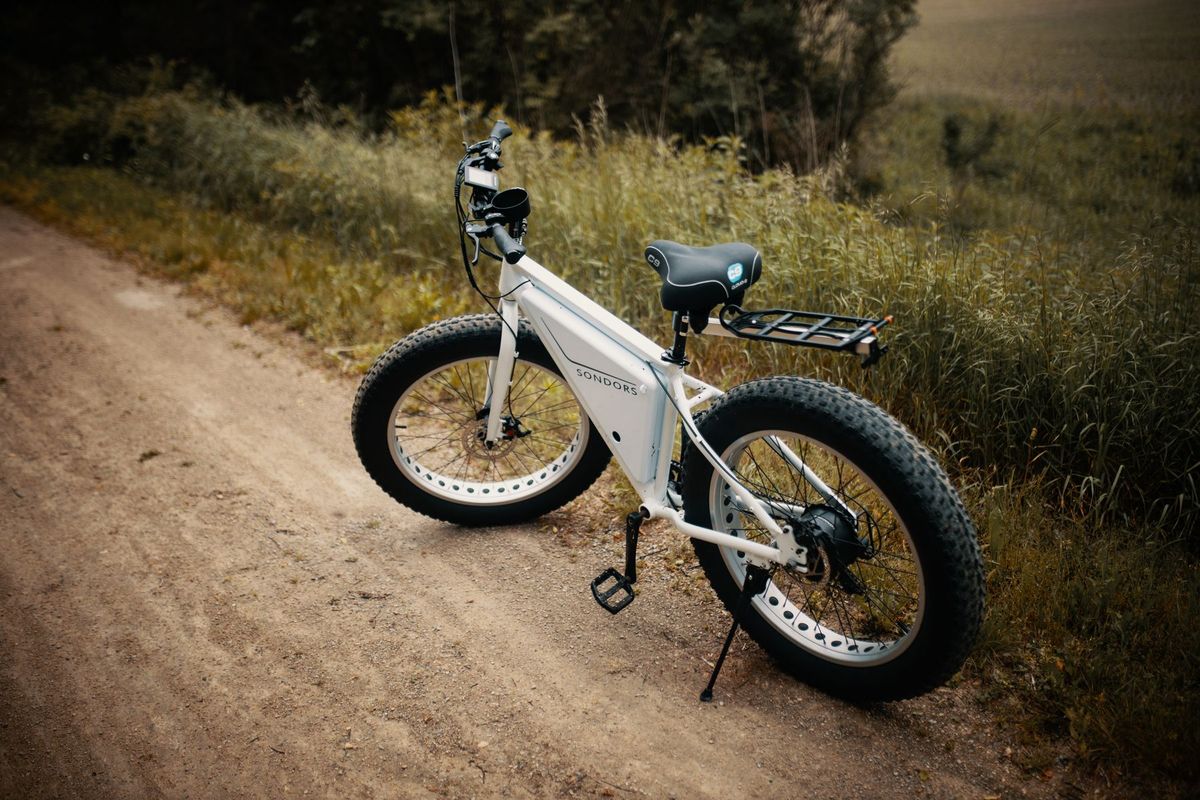White electric bike with fat tires parked on a dirt trail