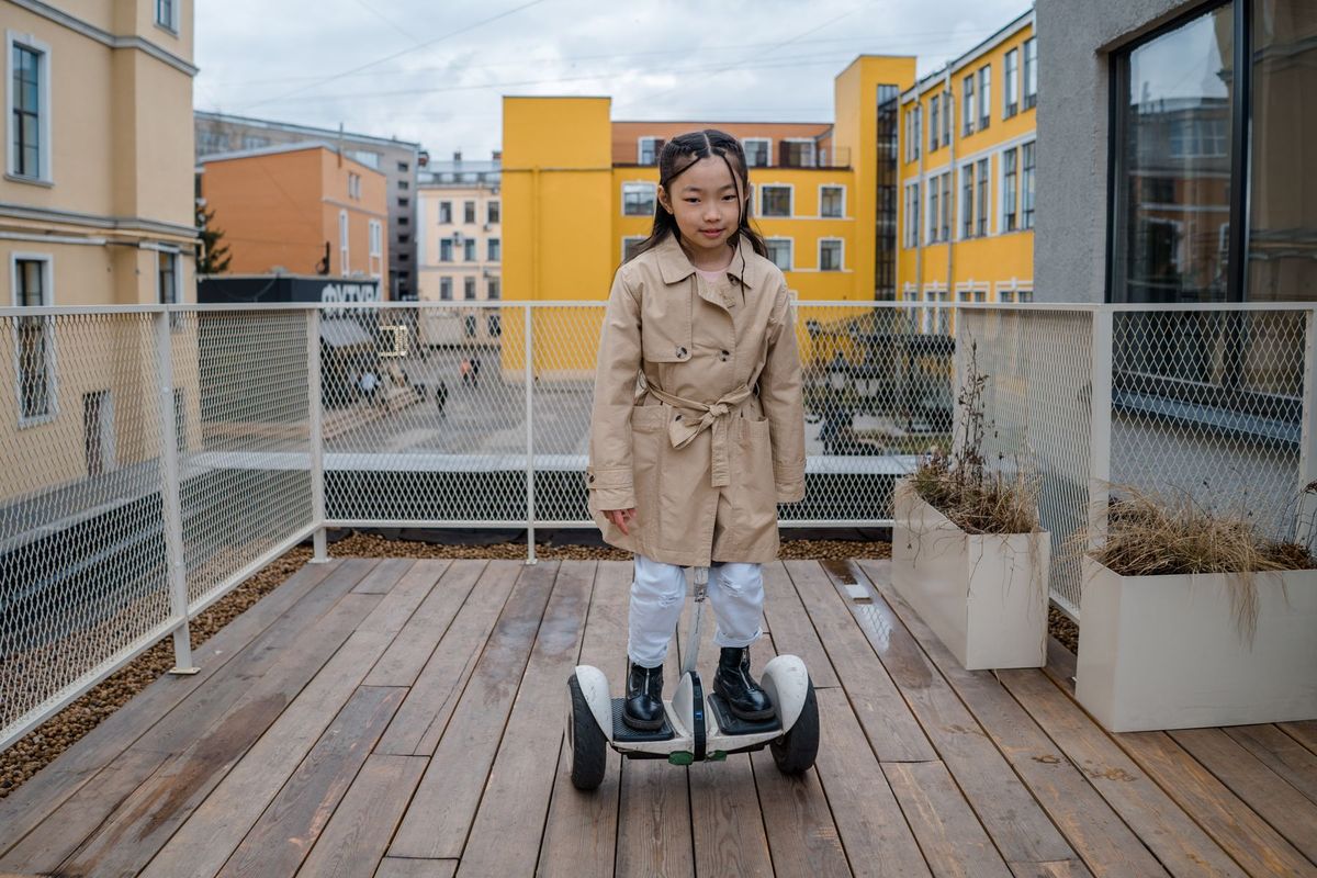 Young girl riding a self-balancing scooter on a wooden deck